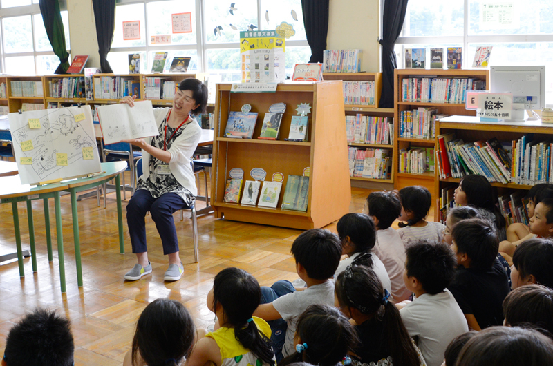 小学生に読み聞かせをする図書館司書の写真