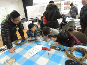 樹名板に樹木の名前を書く様子