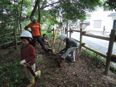 柵沿いのゴミ拾いをする子ども