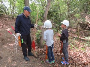 小学生が先輩ボランティアさんの説明を聞いている写真