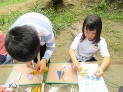 折り紙で七夕飾りを作っている子ども2人の写真