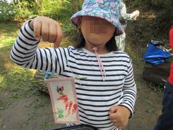 できあがった葉っぱのスタンプを手に持っている女の子の写真