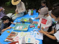 七夕飾りを作っている子ども達と親の写真