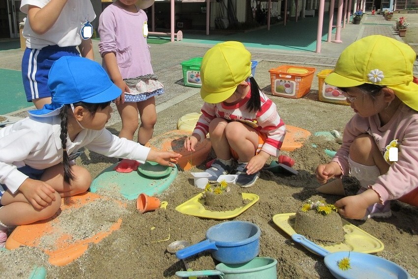 砂場で遊ぶ年少児