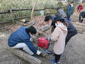 穴を開ける間隔を教えてもらっている親子