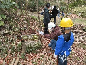 杭を作っている男性とそれを見ている男の子