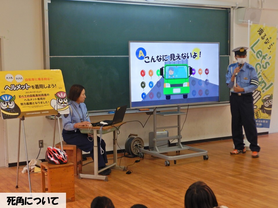 トラックの死角の講話をする警察官