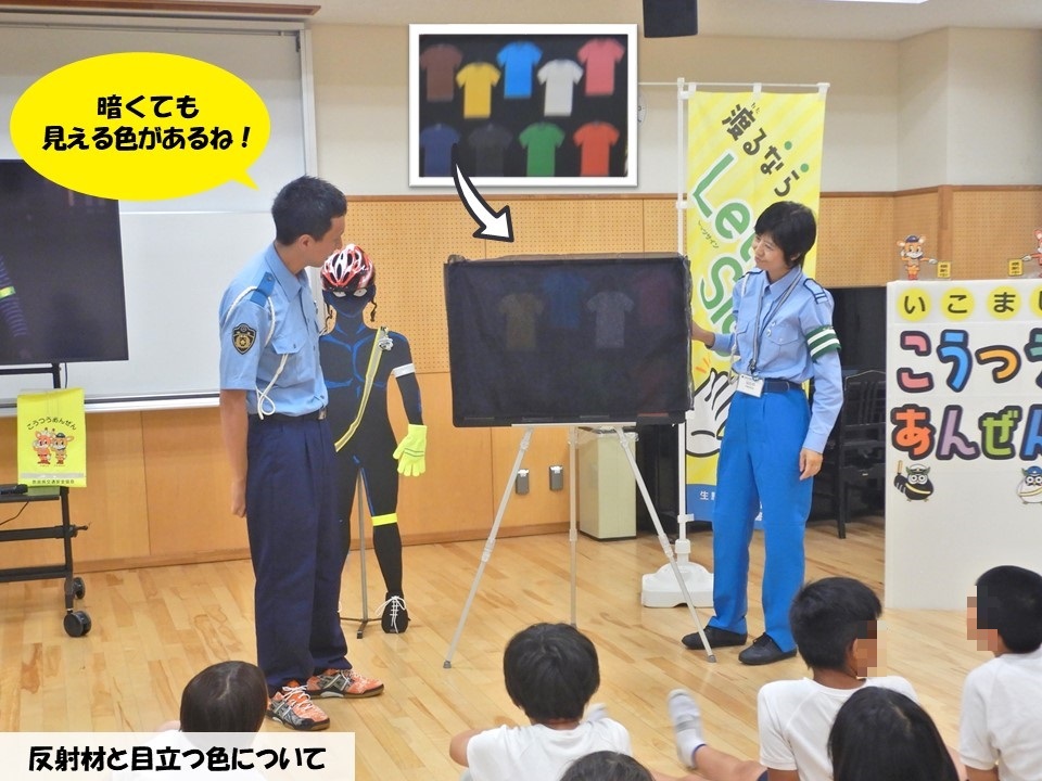 交通教室で暗い所で見えやすい色を説明する警察官