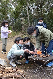 バーベキューをして楽しそうに笑っている子ども達に写真