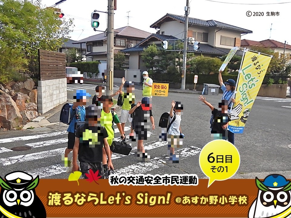 手をあげて横断歩道を渡る小学生1