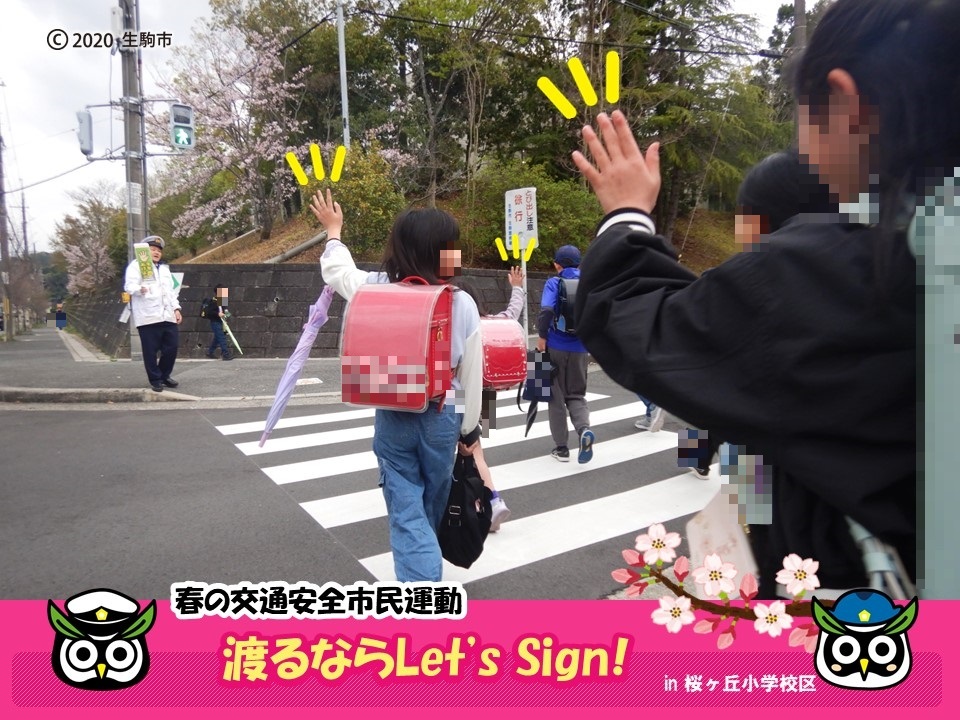 横断歩道を手を挙げて渡る子どもたち