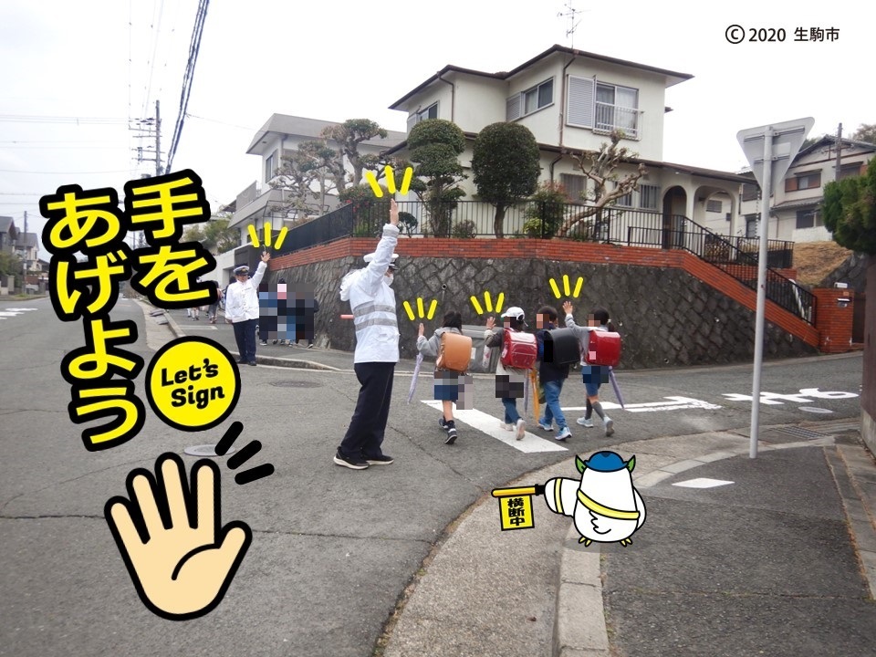 手を挙げて渡る子どもたち