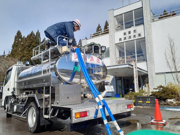 能登町内浦浄水場にて、各所に水を配るため給水車のタンクに水を入れている写真です